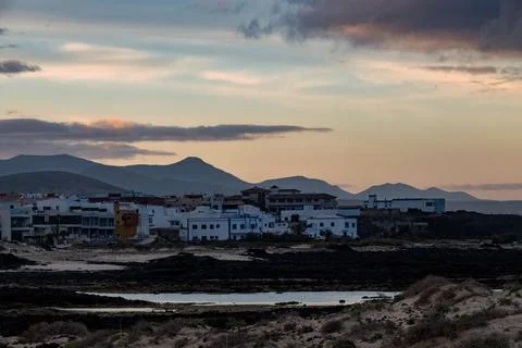 Sunset view of town with mountains and water in the background Stock Photos