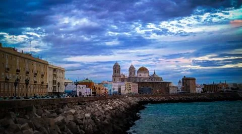 Sunset view to waterfront and Cathedral of Cadiz in Spain Stock Photos