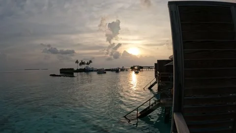 Sunset views over tranquil water in the Maldives with boats and palm trees Video stock 286104730