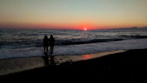 Sunset Walk on the Beach in the Evening With Two People Beside the Water in a Stock-Footage 330796181