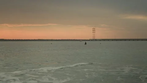 Sunset warm sky sea waves. Sap surfing swimmer diver. Rocky beach Stock Footage 167496437