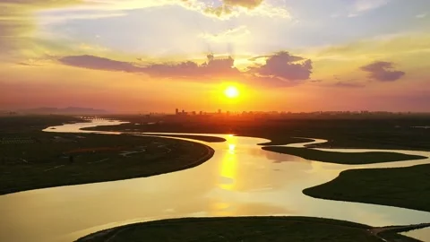At sunset, warm sun shining on a river meander on the grass Stock Footage 153026314