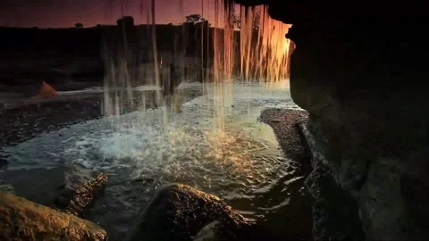 Sunset Waterfall Cascading Over Rocks in Cave Stock Footage 327293227