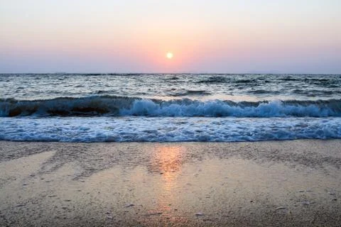 Sunset, wave and the beach Stock Photos