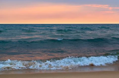 Sunset, waves and sand Stock Photos