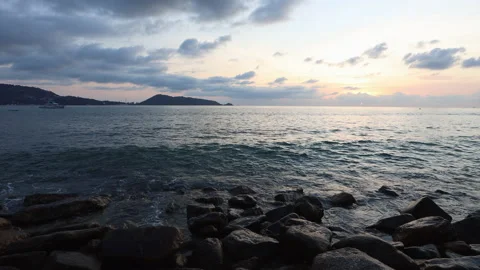 Sunset. Waves crash against large rocks on a beach in Phuket in the evening. Stock Footage 145437002