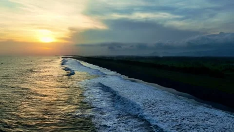 Sunset waves curling along dark coastal beach Video stock 335439264
