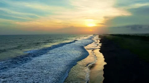 Sunset waves curling along dark coastal beach Stock Footage 335440192