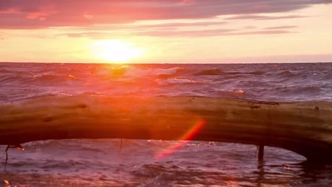 Sunset into waves with driftwood Stock Footage 72941439