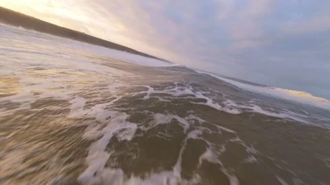 Sunset waves roll over beach, creating frothy textures Stock Footage 344672315