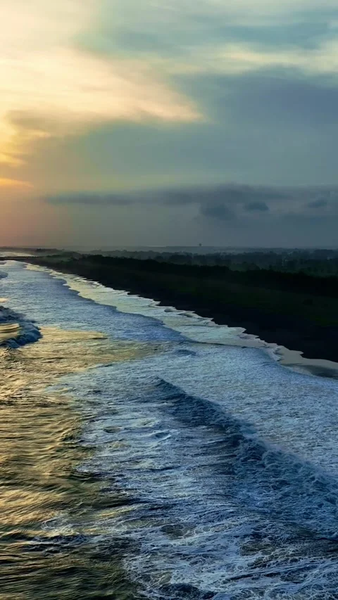 Sunset waves rolling along dark coastal beach Stock-Footage 335432742