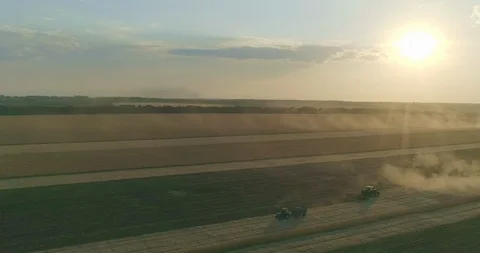 Sunset. Wheat field and tractors gathering in the crops Stock Footage 109340985
