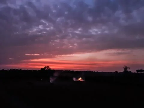 At sunset, the white clouds in the blue sky, the sun's light turned red and s Stock Photos