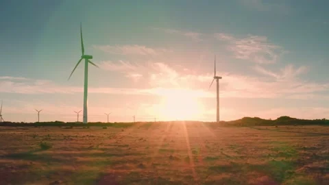 At sunset wind turbines in field wind farm generating green energy. Silhouettes Stock Footage 197531850