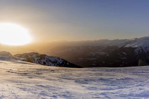 The sunset in winter during a wind storm with the snow being blown away on a  Stock Photos