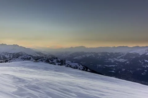 The sunset in winter during a wind storm with the snow being blown away on a  Foto stock
