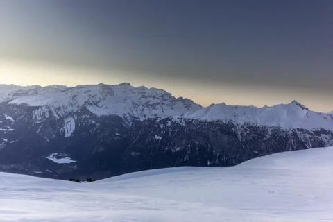The sunset in winter during a wind storm with the snow being blown away on a  Stock Photos
