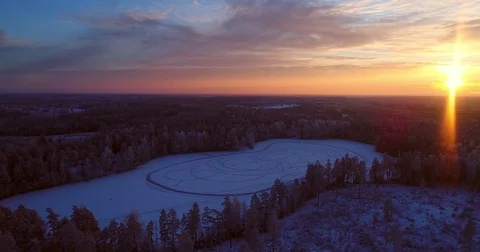 Sunset at a winter pond, Cinema 4k aerial orbit view around a frozen lake, fu Stock Footage 85203487