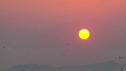 Sunset in the Yellow Sky. Timelapse. Big bright Yellow sun moves down. Stock Footage 171553749