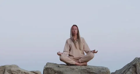 A sunset yoga session on large rocks by the sea Stock Footage 160048145
