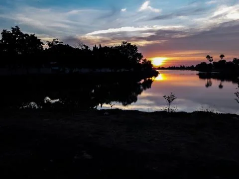 Sunsets behind the pond. Stock Photos