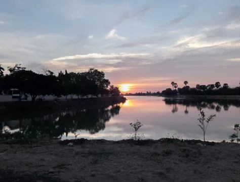 Sunsets behind the pond. Stock Photos