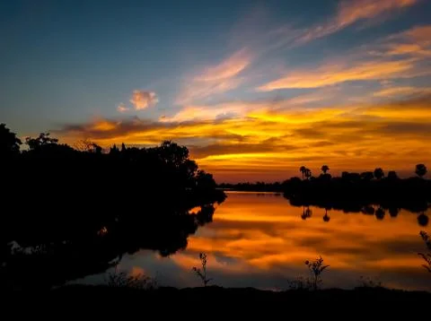 Sunsets behind the pond. Stock Photos