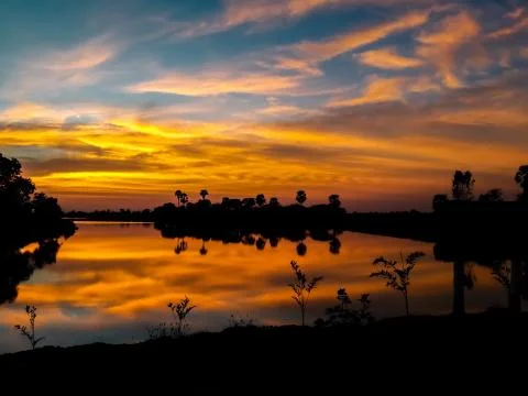 Sunsets behind the pond. Stock Photos