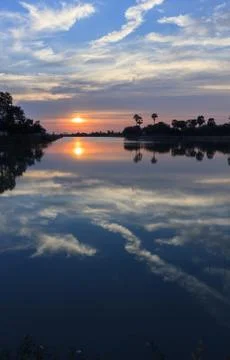 Sunsets behind the pond. Stock Photos