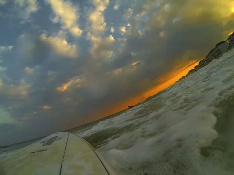 Sunsets while surfer catches waves Stock Footage 42544959