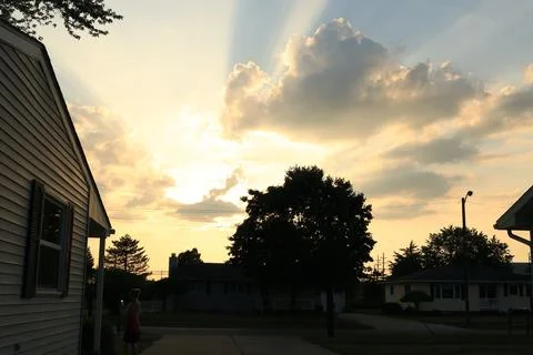 Sunsetting breaking through clouds 库存照片