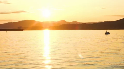 Sunsetting over the ocean and mountains Stock Footage 118475619