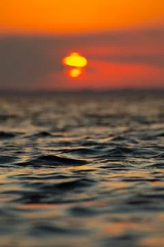 Sunsetting over the ocean waves with vibrant sky Stock Photos