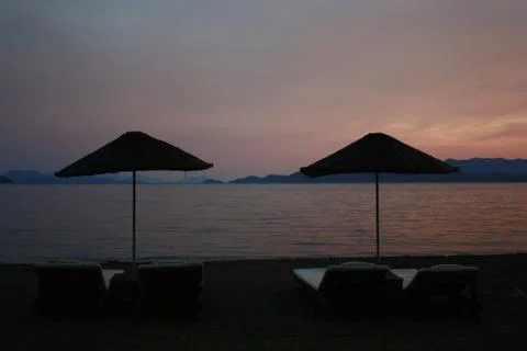 Sunshades in beach at sunset Stock Photos