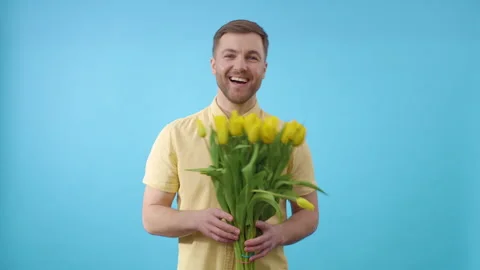 Sunshine in hand: a man embracing yellow tulips Stock Footage 273787250