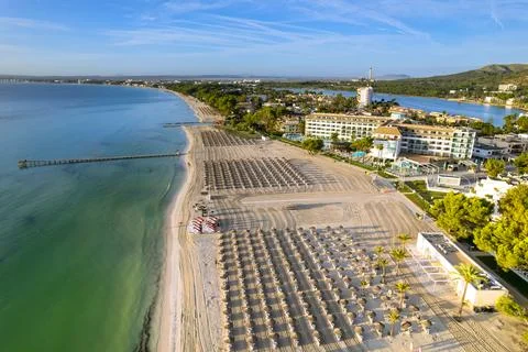 Sunshine hits beach while people relax on sunbeds in Mallorca Balearic Islands Stock Photos