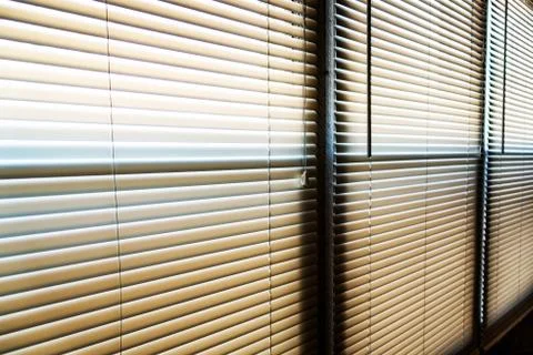Sunshine hitting closed window blinds in the early morning Stock Photos