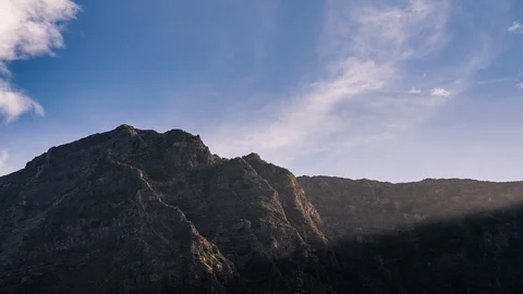 Sunshine over the mountain and clouds passing fast Stock Footage 125937702