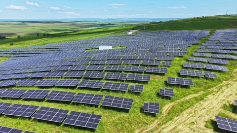 Sunshine reflecting off organized solar array fields. Elevated perspective Stock Footage 337912596