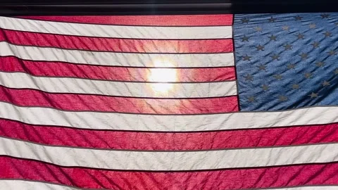 Sunshine Through American Flag 4K Stock Video Stock Footage 246951691
