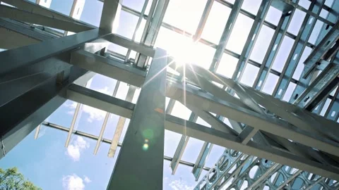 Sunshine through steel metallic building structure,  low angle perspective Stock Footage