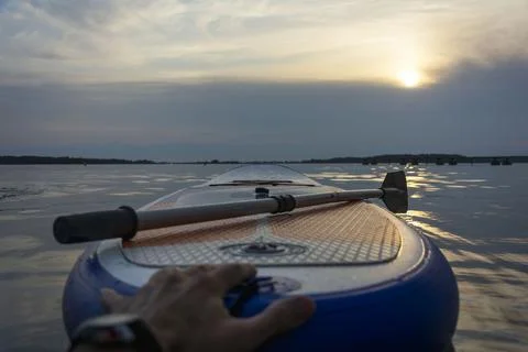 SUP board, Paddle board with a paddle in the sunset light on the background o Stock-Fotos