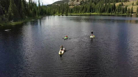 SUP paddle board on mountain lake Wyoming Montana Absaroka Beartooth Wilderness Stock Footage 143722720