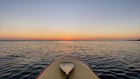 SUP Paddleboard on gentle waves at sunrise Stock Footage 230737149