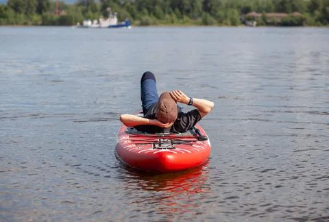 SUP Stand up paddle board man paddle boarding on lake Stock Photos