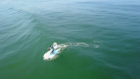SUP surfer catching wave and pan to shoreline Playa Grande Costa Rica Stock Footage 90976148