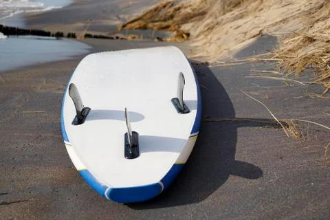 A supboard close-up is horizontal lying on the sandy shore of Lake Michigan Stock Photos