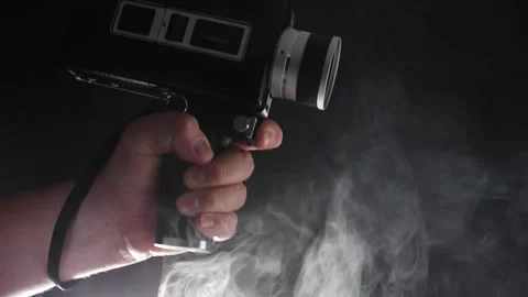 Super 8 camera rising up from the smoke in slow motion film camera movie Stock Footage 205535743
