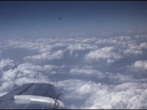SUPER 8 - window view of plane flying over the clouds - 1970 Stock Footage 283762396