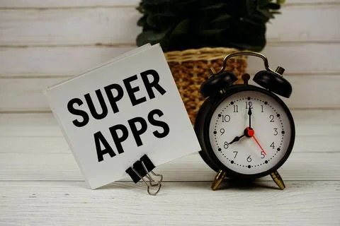 Super Apps text message on sticky note with alarm clcok on wooden background Foto stock